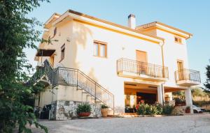 a large white house with stairs on it at Villa Priolo in Ciminna