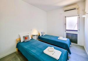two beds in a room with a window at FLH Monte Gordo Summer Flat in Monte Gordo