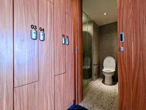 a bathroom with a toilet and a glass shower at Grand Zuri Pekanbaru in Pekanbaru