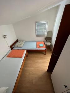 ein kleines Zimmer mit 2 Betten und einem Fenster in der Unterkunft Apartments Tea in Karlobag