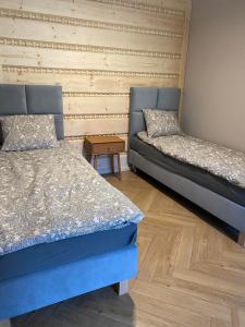 two beds sitting next to each other in a room at Złoty Groń log houses & apartments in Istebna