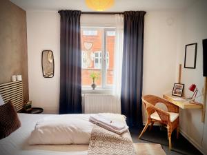a bedroom with a bed and a desk and a window at Hotel Gammel Havn in Fredericia