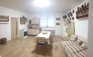 eine Küche mit einem Tisch und Stühlen sowie eine Küche mit einem Herd in der Unterkunft Rodinný penzion Mayer in Pouzdřany
