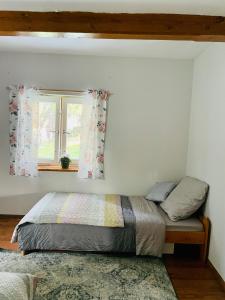 a bedroom with a bed and a window at Domek na farmie in Sztum