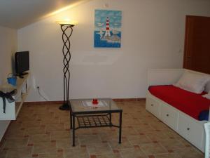 a bedroom with a bed and a table and a lamp at Apartments Dalmatina in Zaton