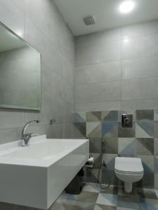 ein Badezimmer mit einem Waschbecken, einem WC und einem Spiegel in der Unterkunft Prestige Hotel Suites - برستيج للشقق الفندقية in Amman
