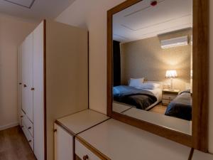 a mirror in a room with a bedroom with two beds at Prestige Hotel Suites - برستيج للشقق الفندقية in Amman +35 photos