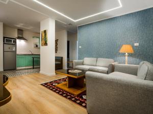 a living room with two couches and a kitchen at Prestige Hotel Suites - برستيج للشقق الفندقية in Amman