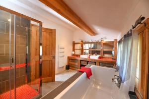 La grande salle de bains est pourvue d'une baignoire et d'une douche. dans l'établissement Vielyterra - Chalet haut de gamme - Domaine du mont blanc, à Saint-Gervais-les-Bains