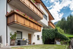 a house with a balcony with flowers on it at Hilber App Fermeda in Villnoss