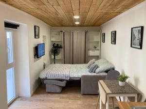 1 dormitorio pequeño con 1 cama y 1 sofá en Affaires ou Loisirs - La Cachette Secrete, en Choisy-le-Roi