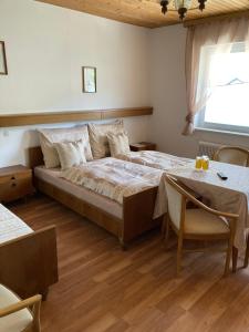 a bedroom with a bed and a table and a window at Moserwirt Pension in Sankt Veit an der Glan