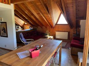 ein Wohnzimmer mit einem großen Holztisch in einem Zimmer in der Unterkunft Chalet Les Rhodos appartement le Yeti in Les Crosets