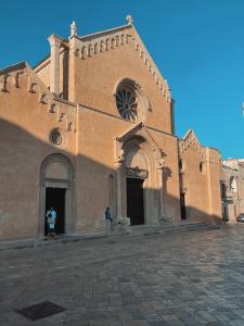 dos personas de pie frente a una iglesia en Suite San Pietro, en Galatina