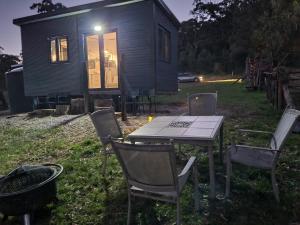 uma mesa e cadeiras em frente a uma pequena casa em Tiny Home - Bluebird em Hartley