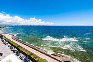 a view of the ocean with cars parked on the beach at Hotel Sunset American in Chatan