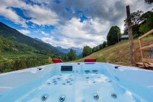 a jacuzzi tub with a view of the mountains at bulle de nuit in La Ferrière
