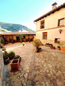 cortile con piante in vaso di fronte a un edificio di Hotel Albarrán ad Albarracín