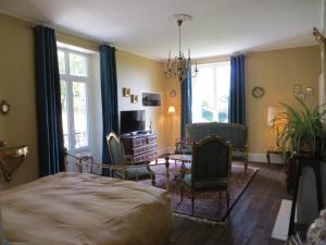 a bedroom with a bed and a table and chairs at Le Bailli de Montsaugeon in Montsaugeon