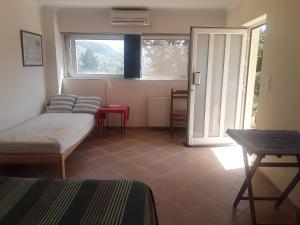 Zimmer mit einem Bett, einem Tisch und einem Fenster in der Unterkunft Alpha House in Plaka