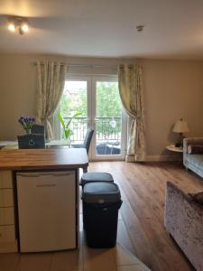 a living room with a kitchen with a trash can at 2Bedroomed apartment on first floor with balcony in Kenmare