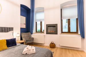 a bedroom with a bed and a chair and windows at Uptown 46 in Braşov