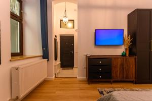 a bedroom with a tv on a wall and a dresser at Uptown 46 in Braşov