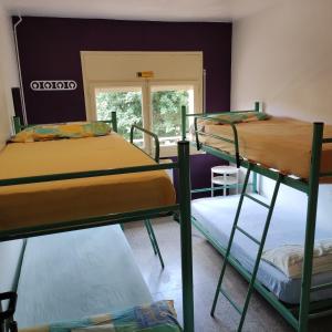 a room with three bunk beds and a window at Alberg Restaurant Bellavista in Santa Pau