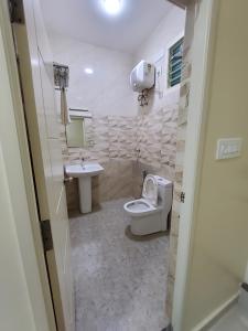 a bathroom with a toilet and a sink at Kings Palace in Chennai