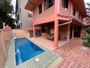 a house with a swimming pool in front of a house at Magadan Residence in Pattaya South