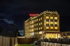 a building with a hotel sign on top of it at Ramada by Wyndham Katra Station Road in Katra