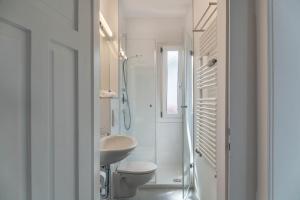 ein weißes Bad mit einem Waschbecken und einem WC in der Unterkunft Fewo im Blauen Haus Dg in Garmisch-Partenkirchen