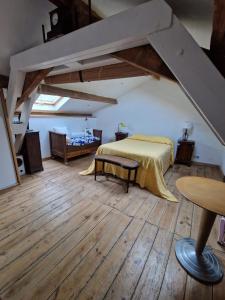 ein Schlafzimmer mit einem Bett in einem Zimmer mit Holzböden in der Unterkunft La maison du vigneron in Auzon