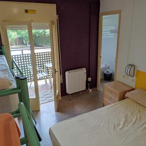 a bedroom with a bunk bed and a balcony at Alberg Restaurant Bellavista in Santa Pau