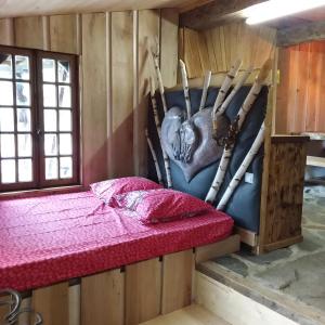 Cette chambre dispose d'un lit avec un cœur sur le mur. dans l'établissement Village.insolite, à Montagny-sur-Grosne