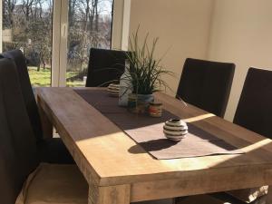 een houten eettafel met zwarte stoelen en een houten tafel bij Das Haus am See in Marienfelde