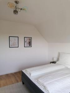 a bedroom with a bed with two pictures on the wall at EIFELSTERN-Schöne Ferienwohnung mit Balkon in Kalenborn-Scheuern