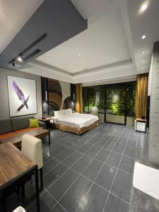 ein Hotelzimmer mit einem Bett und einem Tisch in der Unterkunft Minimalist Fashion Motel in Taoyuan