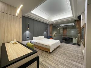 1 dormitorio con cama y escritorio. en Minimalist Fashion Motel en Taoyuan