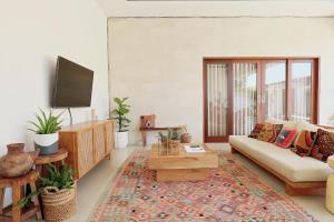 a living room with a couch and a tv at Beautiful Tropical-Boho 3BR Villa, Berawa Canggu, Bali in Canggu