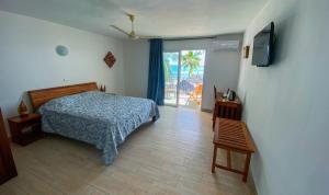 ein Schlafzimmer mit einem Bett und einem TV an der Wand in der Unterkunft Orangea Beach Resort in Andilana