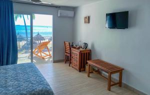 sypialnia z łóżkiem, telewizorem i stołem w obiekcie Orangea Beach Resort w mieście Andilana