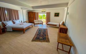 a bedroom with a bed and a living room with a couch at Orangea Beach Resort in Andilana +56 photos