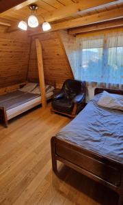 1 dormitorio con 1 cama y 1 silla en una cabaña en Mountain House, en Ustrzyki Dolne