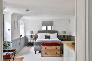 a bedroom with a bed and a chair and a table at The Bothy Beverston Castle in Tetbury