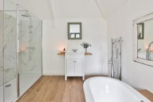 a white bathroom with a tub and a shower at The Bothy Beverston Castle in Tetbury
