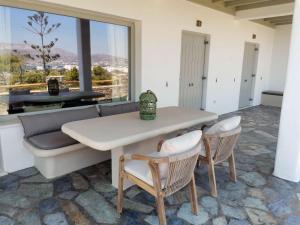 a dining room with a table and chairs and a couch at Degaetas Resort in Antiparos