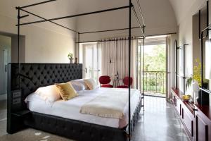 a bedroom with a black canopy bed with a balcony at Laqua Countryside in Vico Equense