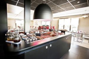 une cuisine avec un buffet de plats sur un comptoir dans l'établissement Hôtel Campanile Strasbourg Aéroport Lingolsheim, à Strasbourg