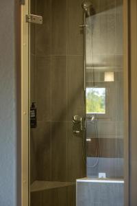 a shower with a glass door in a bathroom at ibis Lyon Nord in Dardilly